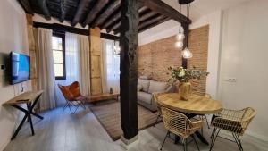 sala de estar con mesa y sofá en Apartamentos Albaicín Centro Suites 3000, en Granada