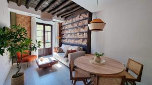 ein Wohnzimmer mit einem Tisch und einem Sofa in der Unterkunft Apartamentos Albaicín Centro Suites 3000 in Granada