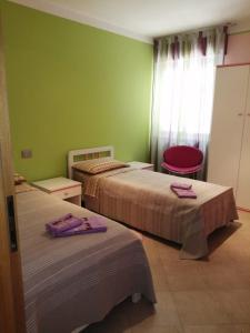 two beds in a room with green walls at Villa Pina in Ferrazzano