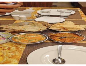 a table with plates of food on it at Hotel Delight Inn, Amritsar in Amritsar