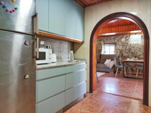 een keuken met een koelkast en een woonkamer bij Casa d´Amado in Sanxenxo