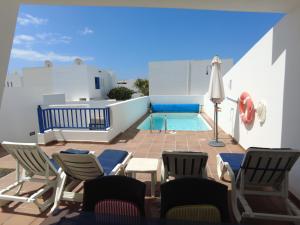 a patio with chairs and a swimming pool at Aloha 45 in Playa Blanca