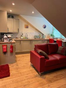 a living room with a red couch in a kitchen at Inviting 1-Bed Studio in Pitlochry in Pitlochry
