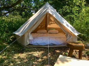 Tienda blanca con cama en el césped en Camp Golstav - Romantic view over the hills., en Flobecq