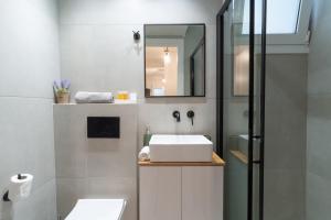 a bathroom with a white sink and a mirror at Aiolos kolonaki vip apartment in Athens