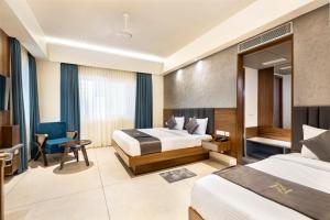 Pokój hotelowy z 2 łóżkami i biurkiem w obiekcie Narthaki Boutique Hotel w mieście Bengaluru