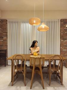a woman sitting at a table in a dining room at Poolvilla Gaon in Busan