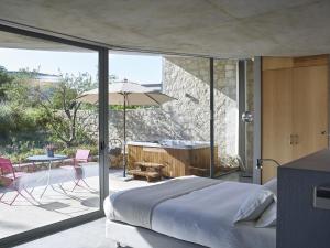 a bedroom with a bed and a patio with a tub at Leivatho Hotel in Svoronata