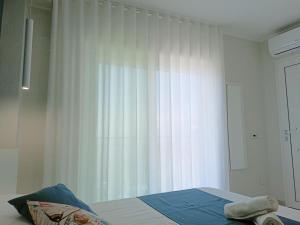 um quarto com uma cama com uma cortina branca em Stanza Mylai Etna View em Castelmola