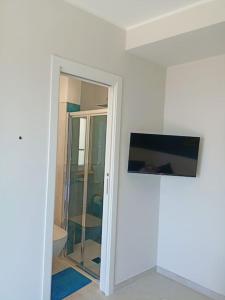 um quarto com uma porta de vidro e um espelho em Stanza Mylai Etna View em Castelmola