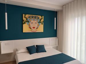 um quarto com uma cama com um quadro de uma mulher em Stanza Mylai Etna View em Castelmola