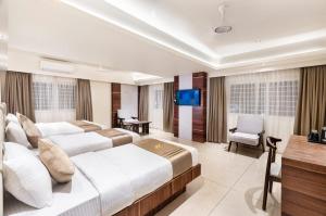 a hotel room with two beds and a flat screen tv at Narthaki Boutique Hotel in Bangalore
