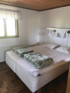 a bedroom with a large bed with a lamp on it at Svalsjöns Stugor Öland in Köpingsvik