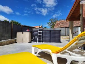 un patio con un banco amarillo y una escalera en Casa d´Amado en Sanxenxo