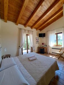 a bedroom with a large bed in a room with windows at Casale Terre Rosse in Saturnia