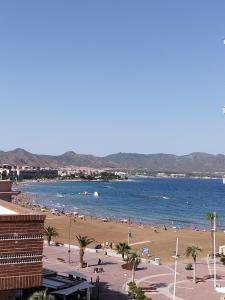 una playa con un montón de gente en la playa en Capitanía frente al mar en Puerto de Mazarrón