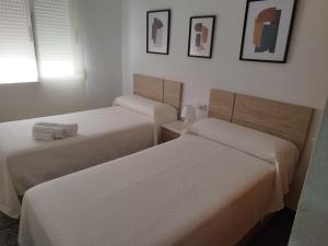 two beds in a room with white walls at Capitanía frente al mar in Puerto de Mazarrón