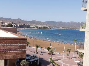 uma vista para uma praia com pessoas na água em Capitanía frente al mar em Puerto de Mazarrón