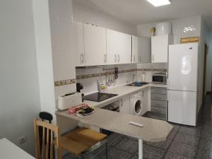 a kitchen with white cabinets and a counter top at Capitanía frente al mar in Puerto de Mazarrón