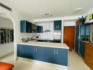 uma cozinha com armários azuis e um lavatório em Alina365 Euromarina 78 em La Manga del Mar Menor