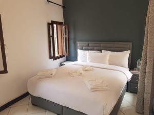 1 dormitorio con 1 cama blanca grande y toallas. en Dar Suncial, en Marrakech