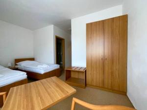 um quarto com duas camas e uma mesa e um armário em Apartmán u Sázav č.16 em Chocerady