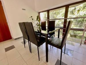 mesa de comedor y sillas en una habitación con ventana en Apartmán u Sázav č.16, en Chocerady