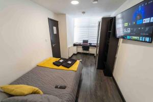 a small room with two beds and a flat screen tv at Cosy Ensuite style studio close to university! in Birmingham