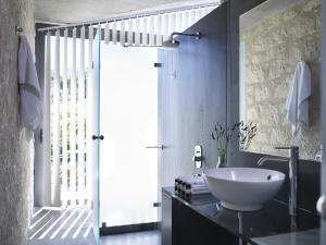 a bathroom with a white sink on a black counter at Leivatho Hotel in Svoronata