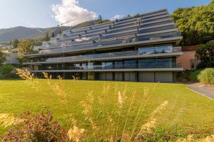 a large building with a lawn in front of it at Panoramic Minusio by Quokka 360 - Luxury with Lake View in Minusio