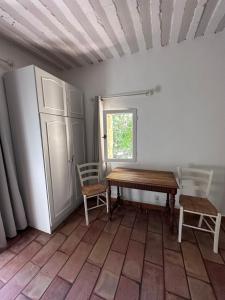 a room with a table and chairs and a refrigerator at Moulin d'Antelon B&B in Crillon-le-Brave