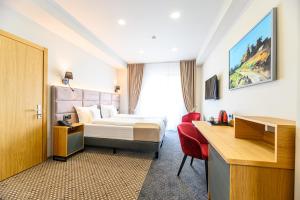 a hotel room with a bed and a desk at Hotel DUKAT in Gura Humorului