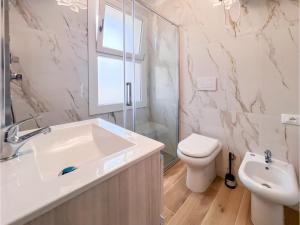 a white bathroom with a sink and a toilet at Patrizia in Bibione +27 photos