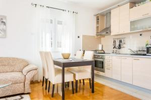 a kitchen with a table and chairs in a room at Apartments with a parking space Seget Donji, Trogir - 21374 in Trogir