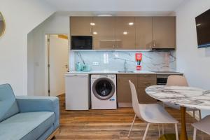 a kitchen with a washing machine and a table at Bonneville Setúbal I, By Home Match in Setúbal