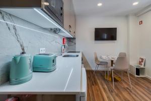 a kitchen with a white counter top and a table at Bonneville Setúbal I, By Home Match in Setúbal