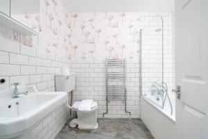 a white bathroom with pink flamingos on the wall at Stunning 3 Bedroom Duplex with Terrace in Brighton & Hove