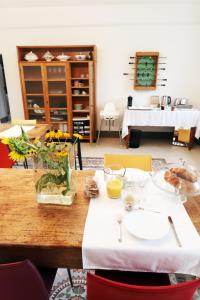 una mesa de madera con un jarrón de flores. en B&B Tricudai, en Agliano Terme