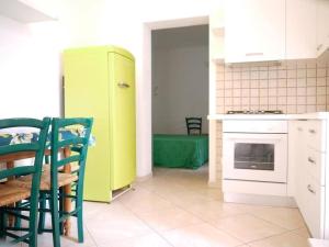 a kitchen with a yellow refrigerator and a table and chairs at Rimini in villa in Rimini