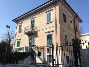 duży dom z płotem przed nim w obiekcie Rimini in villa w Rimini