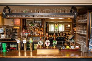 a bar with a lot of bottles of alcohol at Cross Hands Hotel by Greene King Inns in Yate