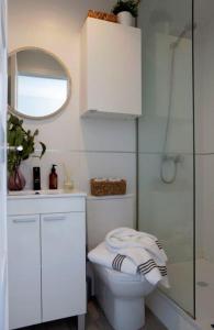 a bathroom with a toilet and a sink and a mirror at Ático con espectacular terraza en Bernabéu in Madrid