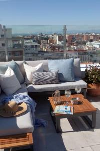a couch and a coffee table on a balcony at Ático en Bernabéu con gran terraza, Paseo de la Castellana in Madrid