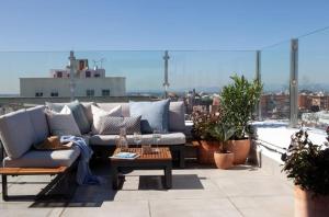 a patio with a couch and a table on a roof at Ático con espectacular terraza en Bernabéu in Madrid