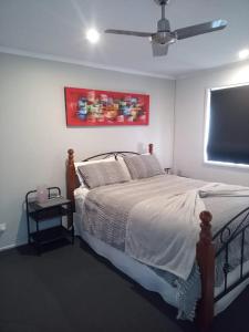 a bedroom with a bed and a tv on the wall at Golfside Getaway in Rosebud