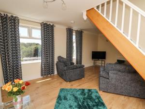 a living room with two chairs and a staircase at 2 Sunny Hill in Haverfordwest