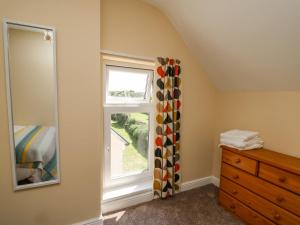 um quarto com uma janela e uma cómoda em madeira em 2 Sunny Hill em Haverfordwest