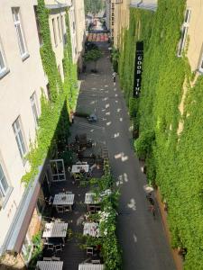 una calle vacía con mesas y sillas en un callejón en Good Time Aparthotel, en Łódź