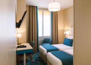 um quarto de hotel com duas camas e uma janela em Hotel Des Remparts Perrache em Lyon