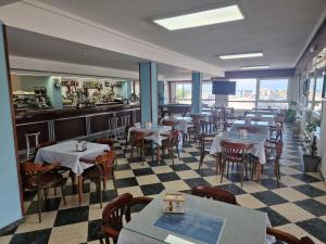 a restaurant with tables and chairs and a counter at Hotel Costa de Ajo in Ajo